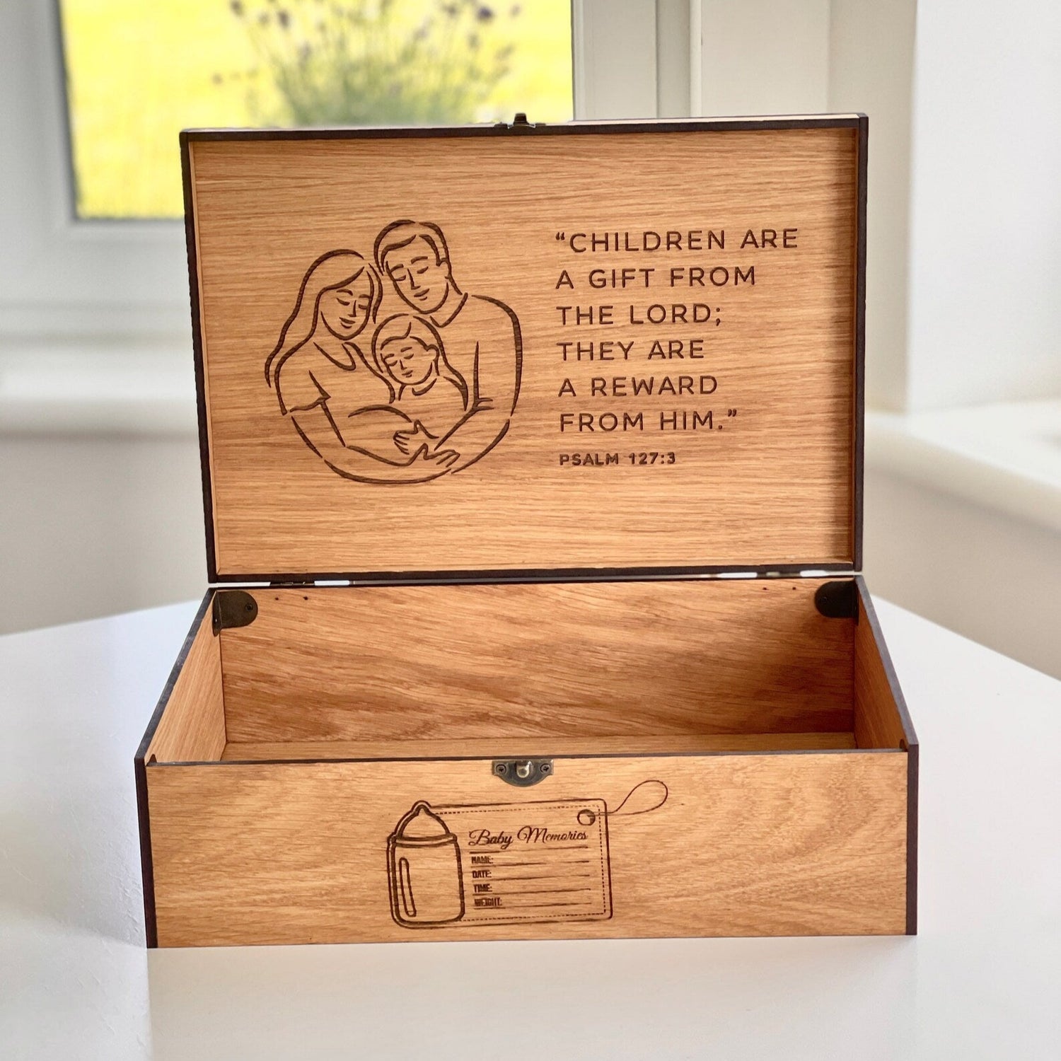 Wooden box with engraved text and illustrations on a white surface.