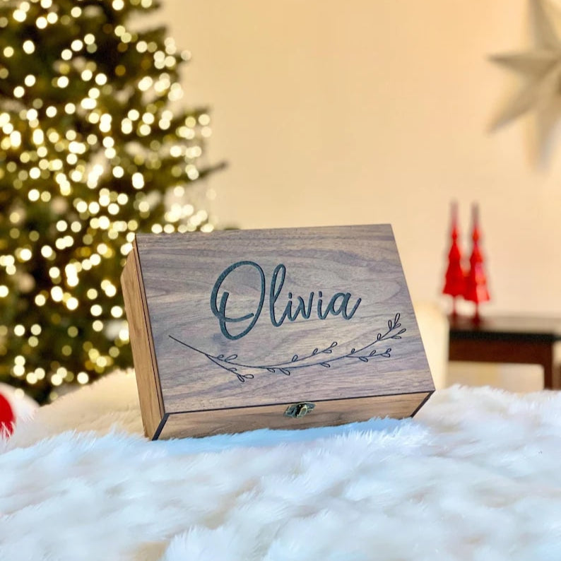 Wooden box with 'Olivia' engraved, Christmas tree in the background