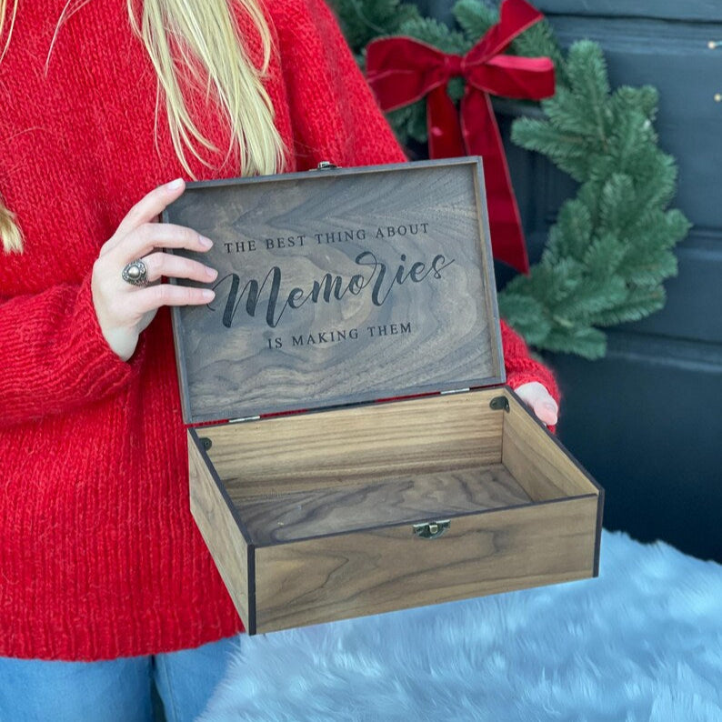 Person holding a wooden box with engraved text in front of a festive background