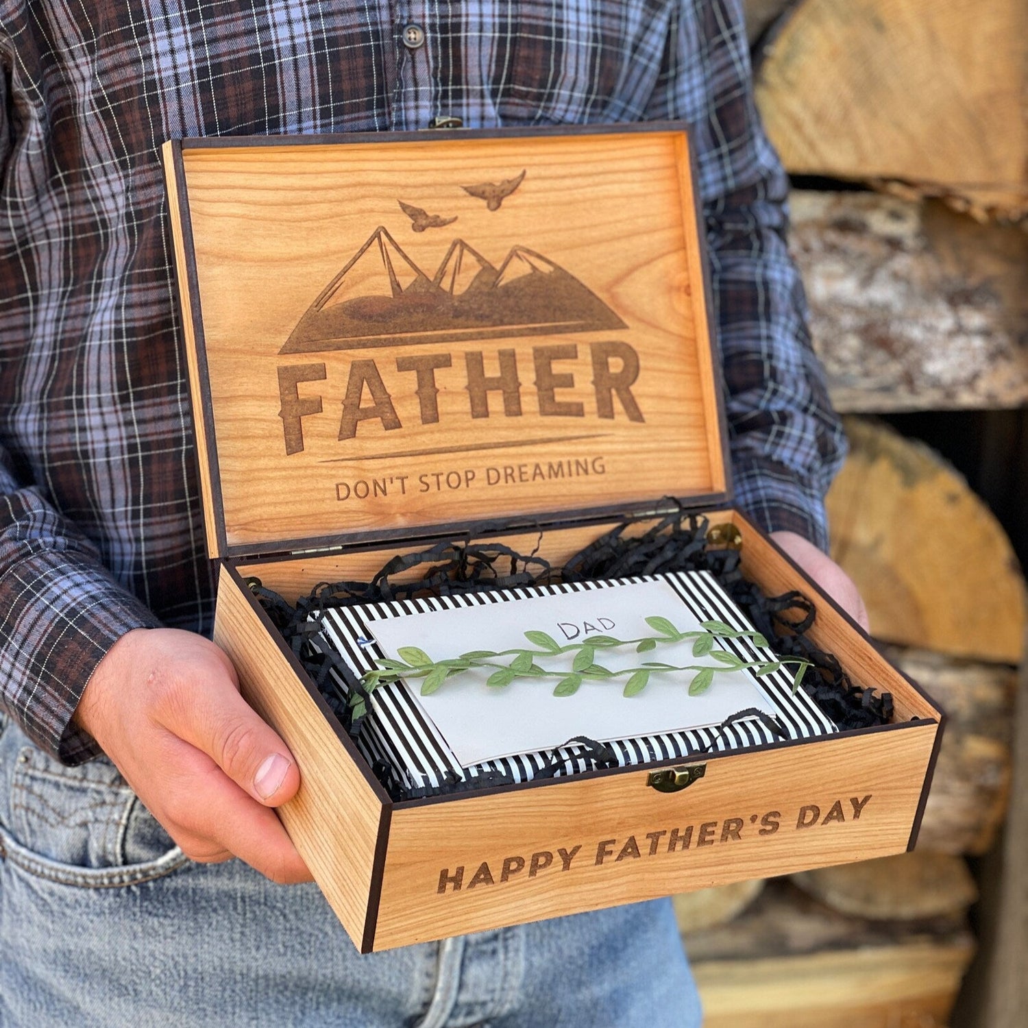 Person holding a wooden Father's Day gift box with engraved text and design.