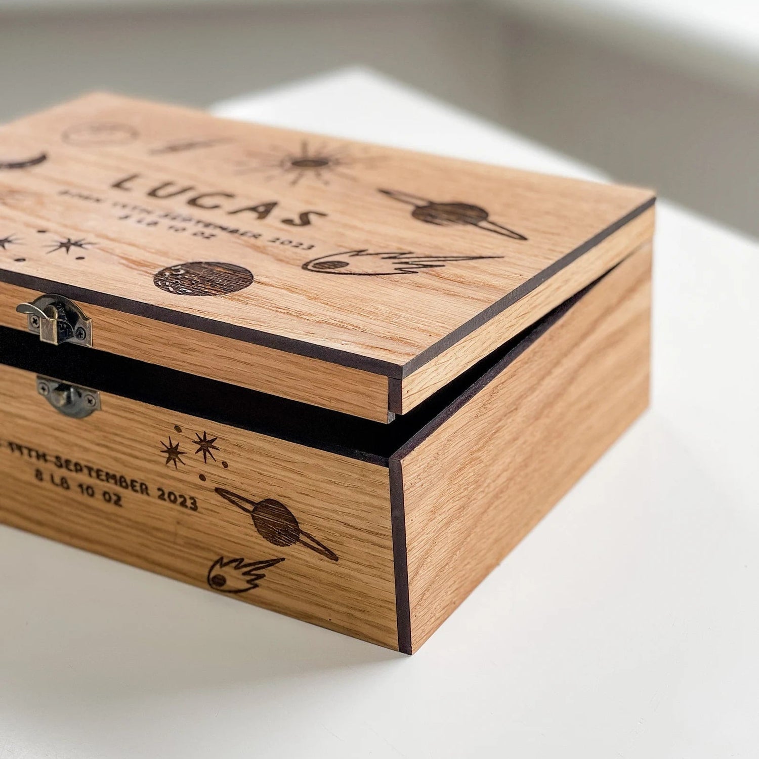 Wooden box with engraved text and design on a white surface