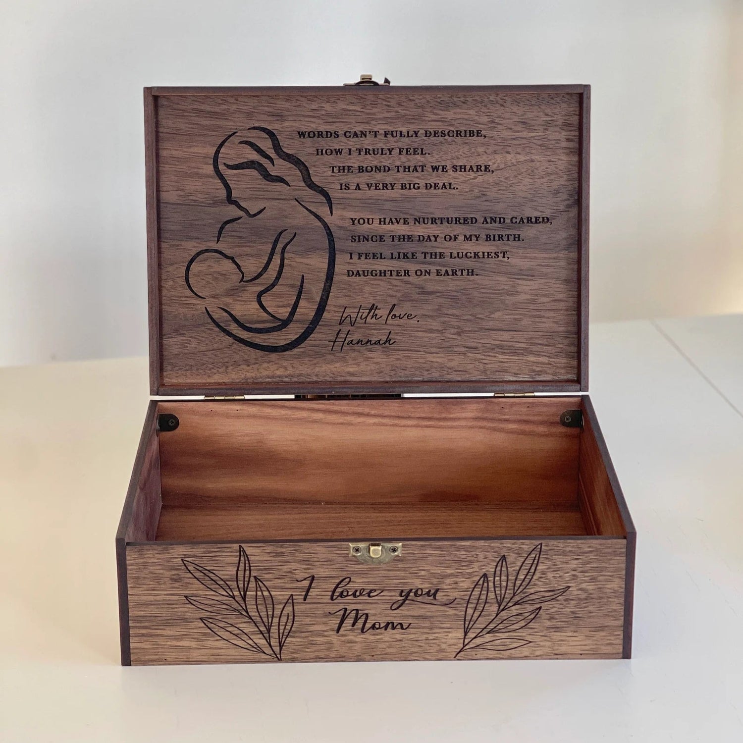 Wooden box with engraved text and silhouette design on a white background