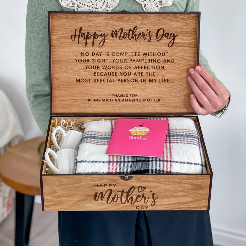 Wooden gift box with Mother's Day message and contents, held by a person.