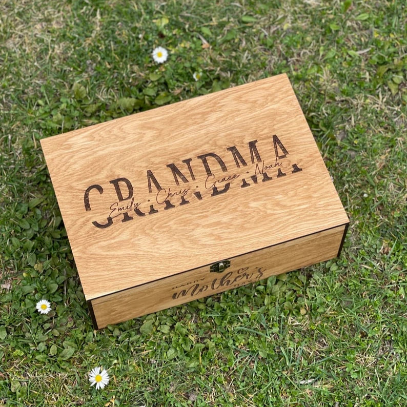 Wooden box engraved with 'Grandma' on a grassy background