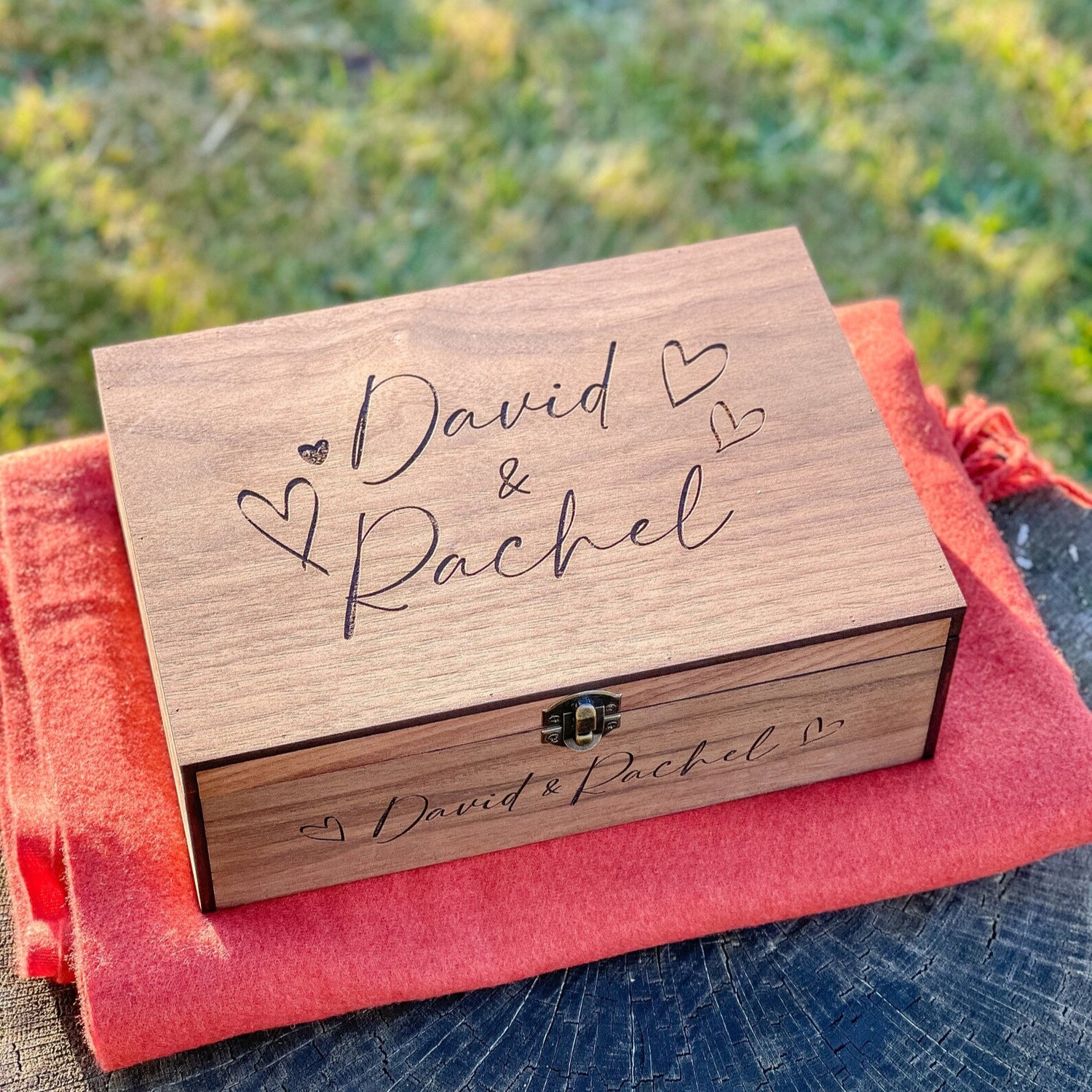 Wooden box with 'David & Rachel' engraving on a red fabric background