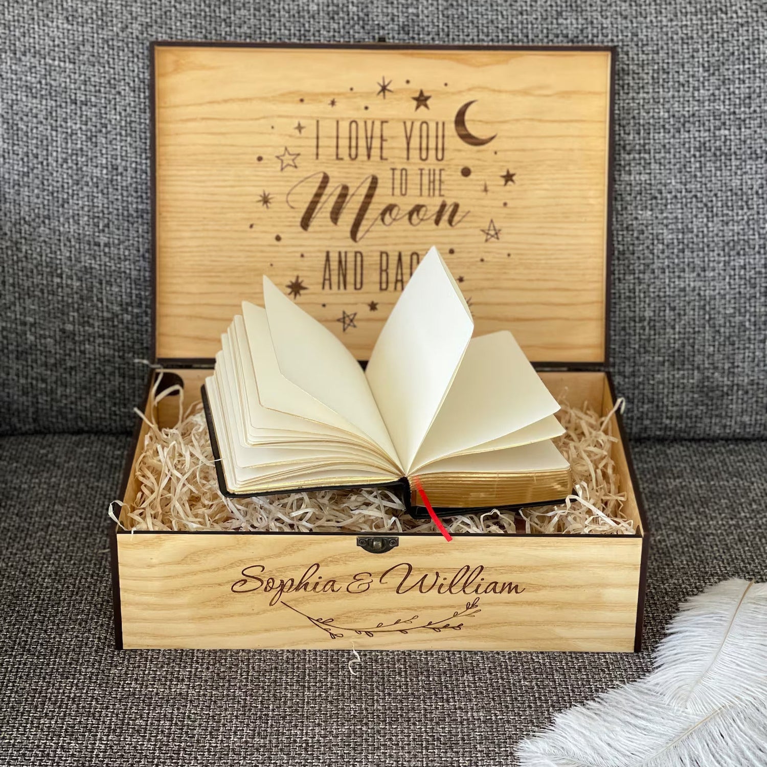 Wooden box with an open book inside, engraved with 'I love you to the moon and back' and personalized names.