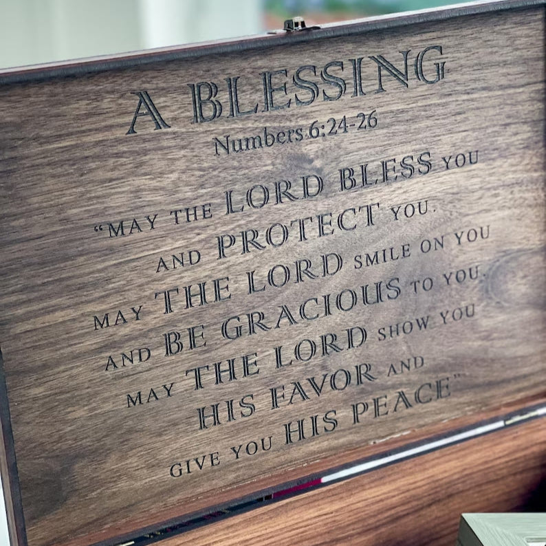 Wooden box with engraved Bible verse on a blurred background